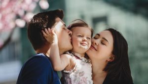 happy-young-parents-with-little-daughter-stand-blooming-pink-tree-outside_8353-7690.jpg
