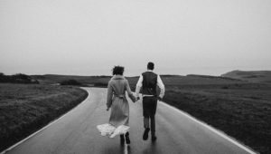 grayscale-photo-of-couple-walking-on-road-3617517